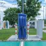 Veículo elétrico em estação pública de recarga com estrutura de design sustentável.