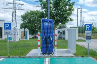 Veículo elétrico em estação pública de recarga com estrutura de design sustentável.