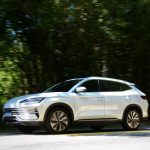 SUV branco trafegando por uma estrada cercada por vegetação, em Monteiro Lobato (SP), durante o dia