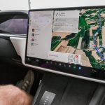 Interior de um carro moderno com uma ampla tela de navegação exibindo um mapa digital detalhado.