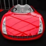 Carro-conceito vermelho exposto em ambiente interno de uma mostra automotiva.